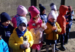 Dzieci trzymające znicze.